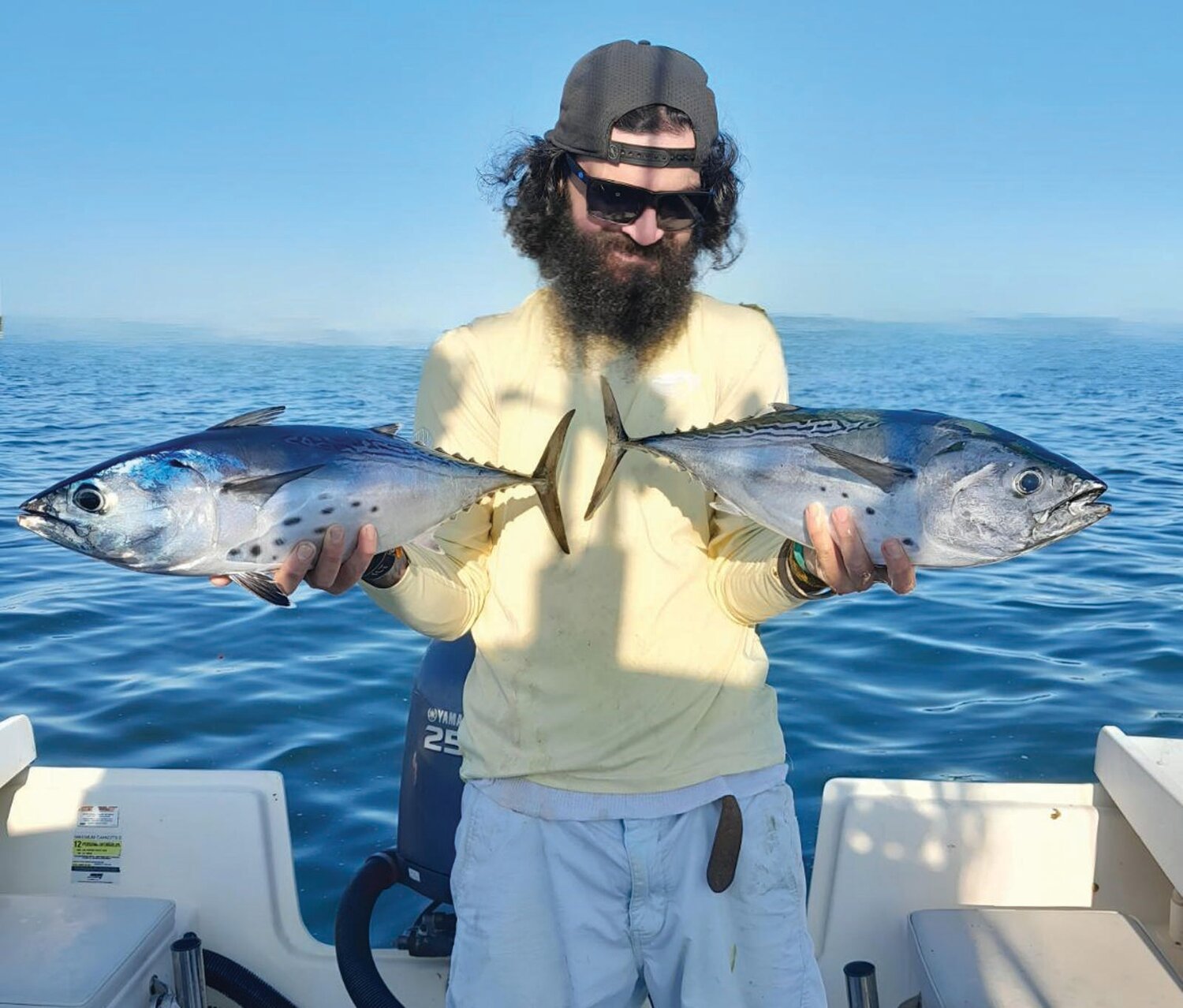 DOUBLE HOOK-UP: Jeff Sullivan of Lucky Bait & Tackle, Warren, with the two false albacore he caught at the same time while working two fishing rods off Brenton Reef, Newport. (Submitted photos)